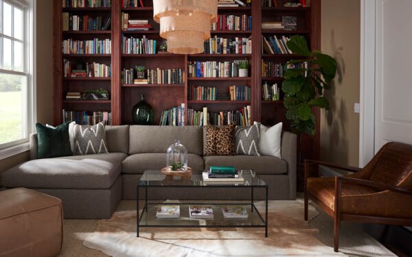 the mt company living room with bookshelf, sofa, coffee table and hanging lamp