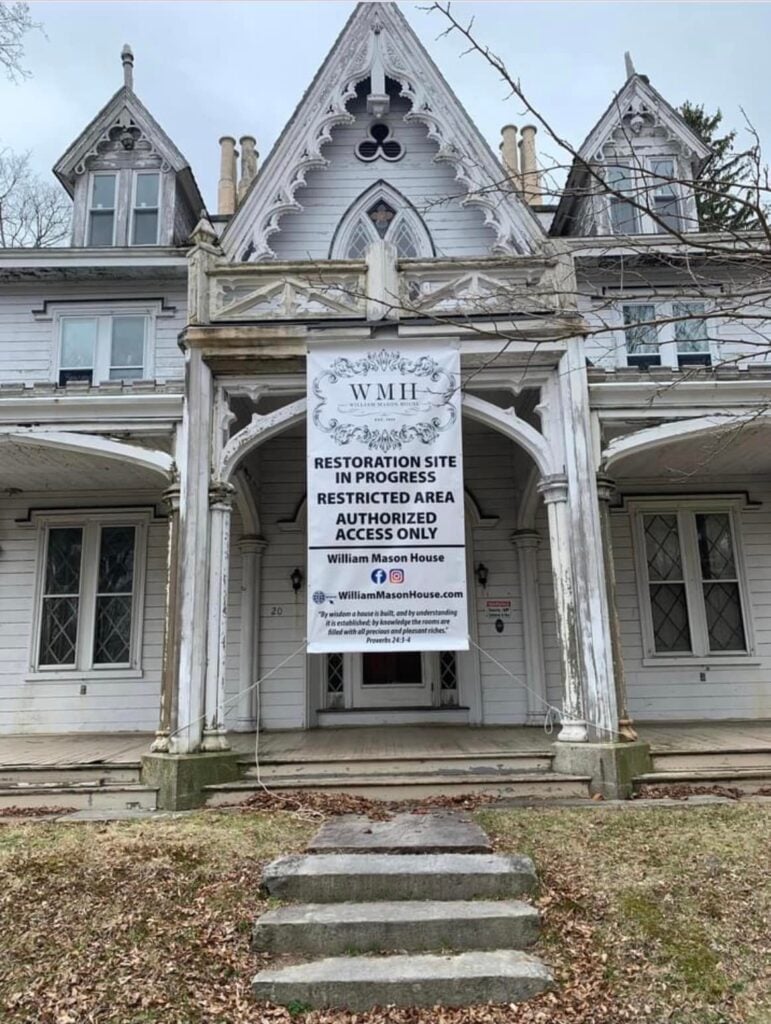 Dilapidated white NeoGothic-style house