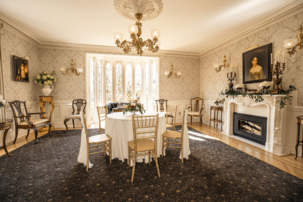 Light-filled sitting room with a table, chairs, and fireplace