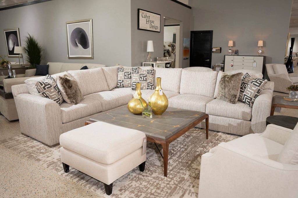 White sectional with metallic gold vases on a gold veined marble table