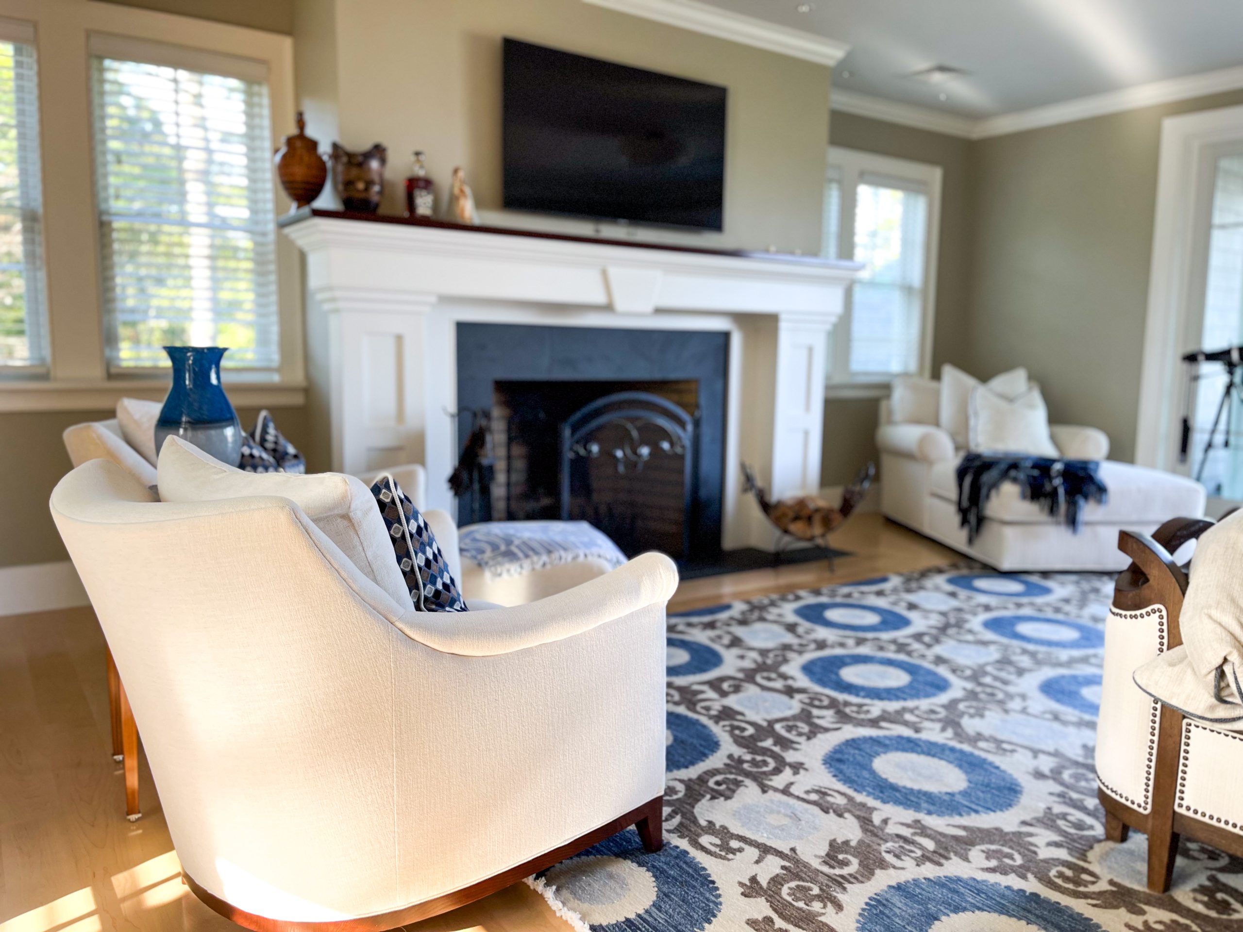 A bedroom with fireplace in shades of cream, brown, and blue.