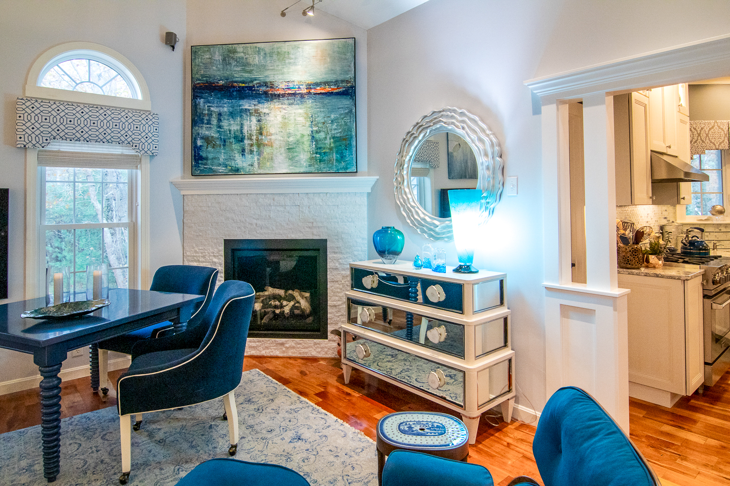 A room with blue chairs and a unique chest of drawers decorated with seashells